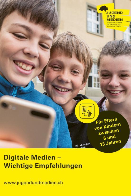 Das Cover des Flyers «Digitale Medien» zeigt drei lachende Kinder die auf ein Handy schauen.