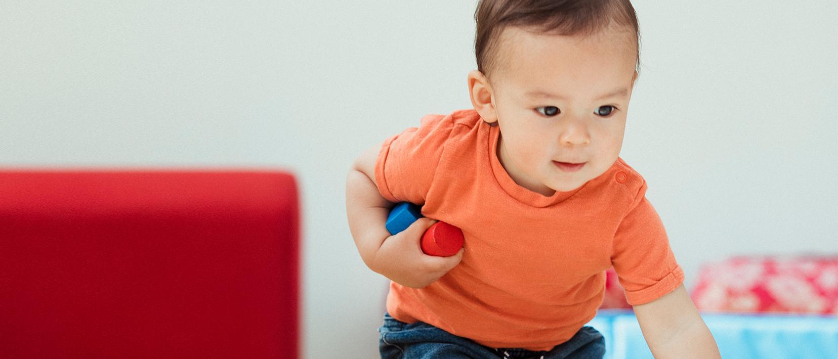 Zweijähriger spielt alleine im Zimmer.