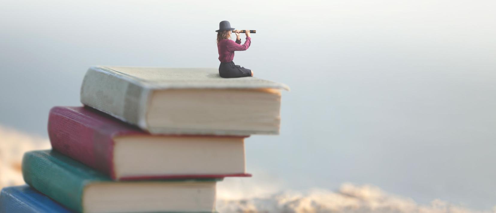 In einer Fotomontage sitzt eine Frau mit Hut auf einem Bücherstapel und schaut mit einem Fernrohr in die Weite.