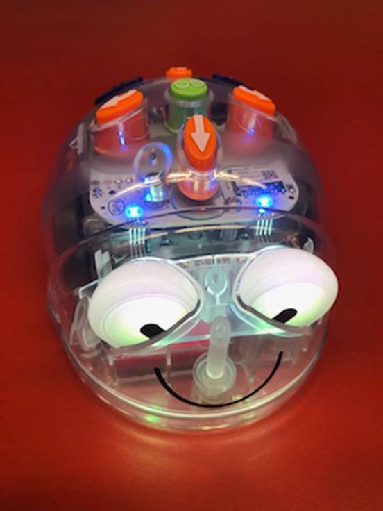 Blue-Bot, ein programmierbarer Bodenroboter, steht auf rotem Untergrund.