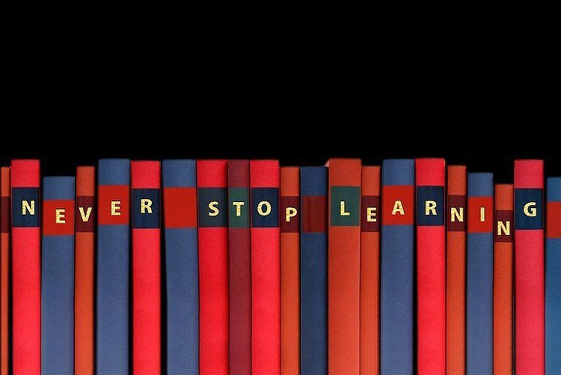Mehrere Buchrücken bilden den Satz: Never stop learning.