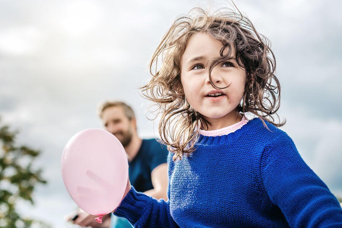 Kind mit Luftballon und Vater