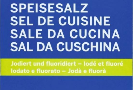 Text auf blauem Grund: «SPEISESALZ» und darunter «Jodiert und fluoridiert» in mehreren Sprachen auf gelbem Balken.