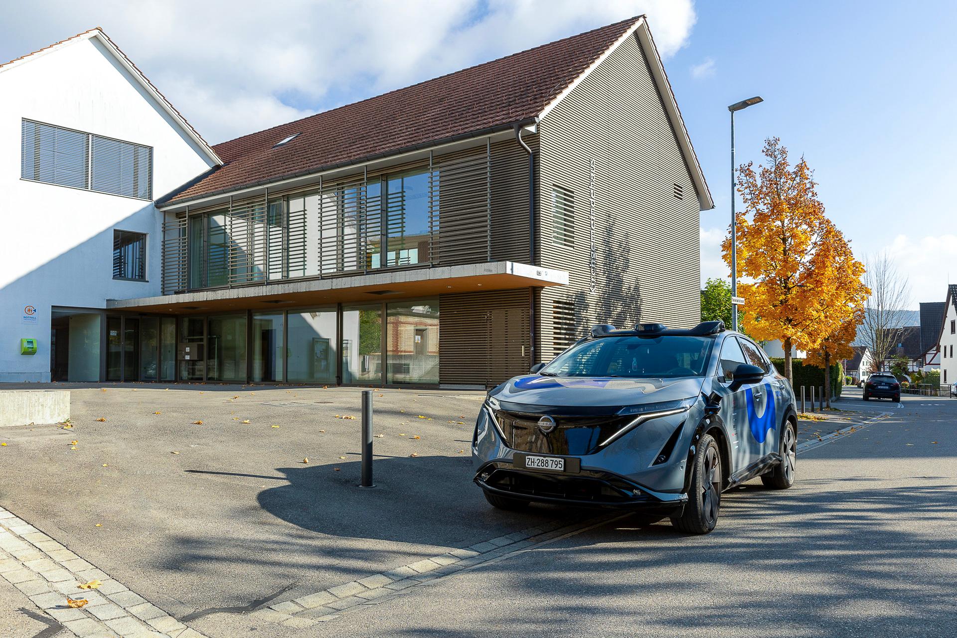 Ein selbstfahrendes Fahrzeug steht vor dem Gemeindehaus in Otelfingen, Kanton Zürich.