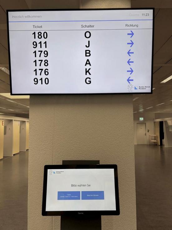 Ticket-Computer und Bildschirm mit dem Schalter·namen.