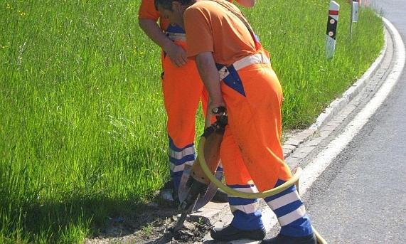 Zwei TBA-Mitarbeitende an Reparaturarbeiten an einem Strassenrandabschluss