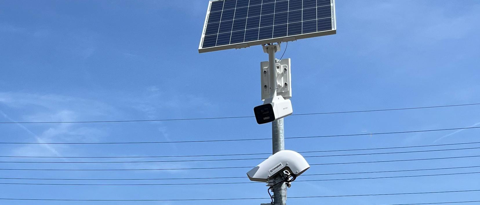 Solarenergiebetriebene Frühwarnanlage mit Kamera und Sensor an einem Mast.