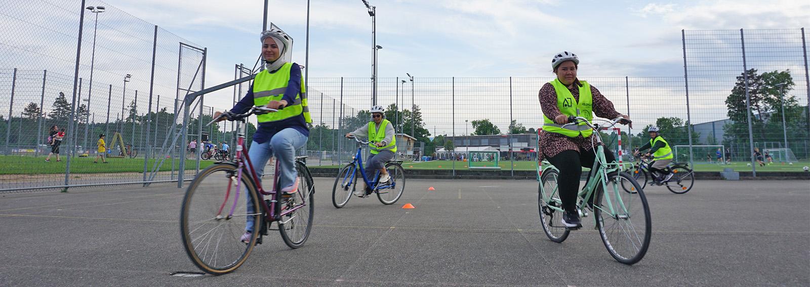 Teilnehmende eines Velofahrkurses für Geflüchtete üben Velofahren