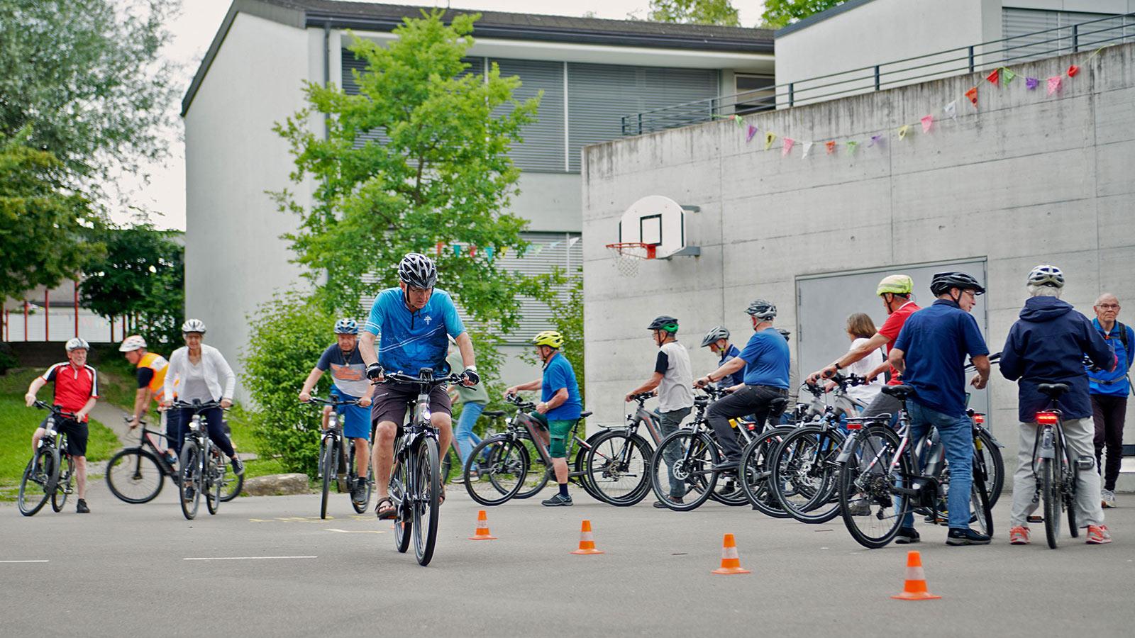Teilnehmende fahren um laufend enger aufgestellte Pylonen.