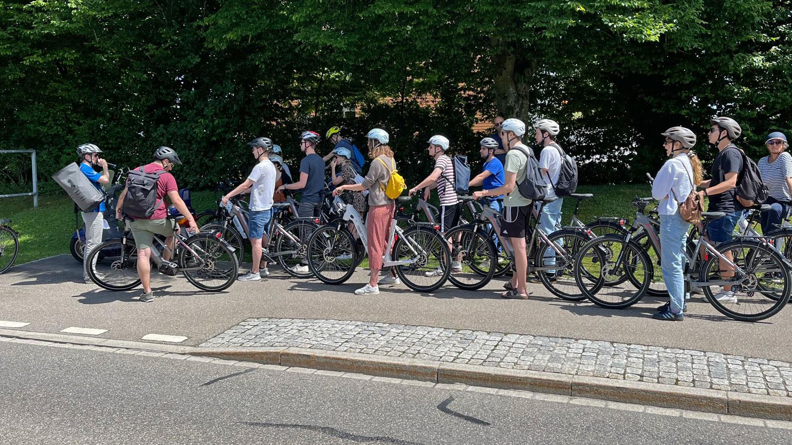 Eine Gruppe hält am Rande einer Radquerung. Dabei werden enge Kurvenradien erläutert.