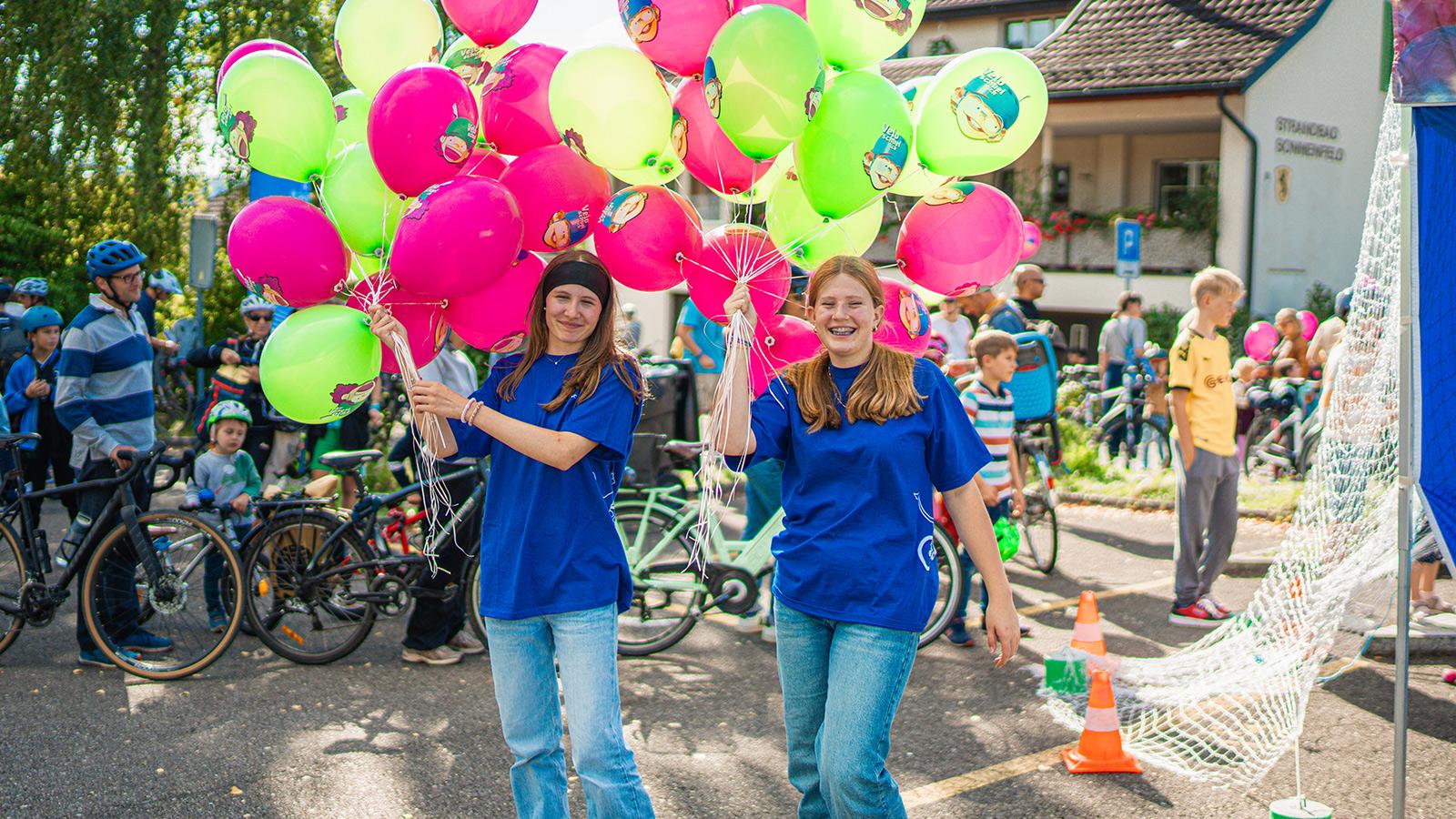 Bild mit zwei jungen Frauen und bunten Luftballons am grossen Velofest SlowUp Zürichsee