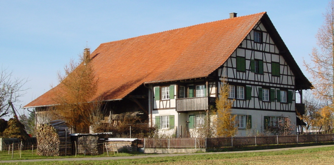 Landwirtschaftliches Wohngebäude umgeben von Einzelbäumen