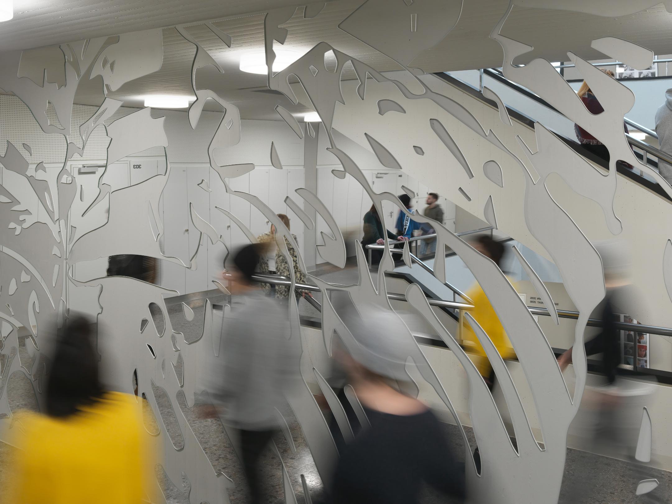 Verschwommene Personen vor einem Spiegel, welcher mit milchigen Formen verziert ist.