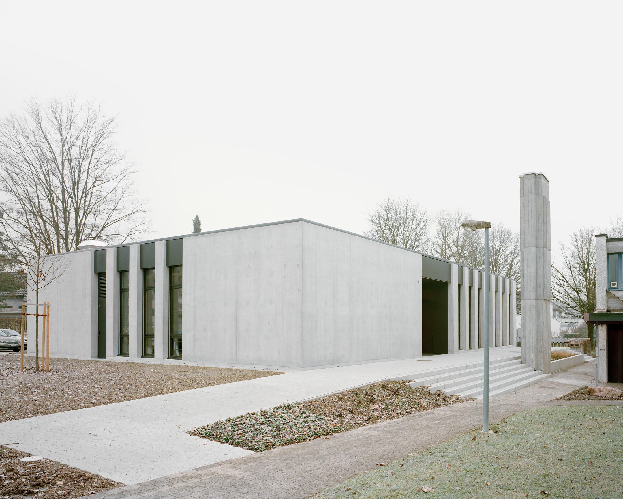 Aussenansicht auf den kubischen Neubau. Im Vordergrund ist der zugefrorene Garten zu sehen.