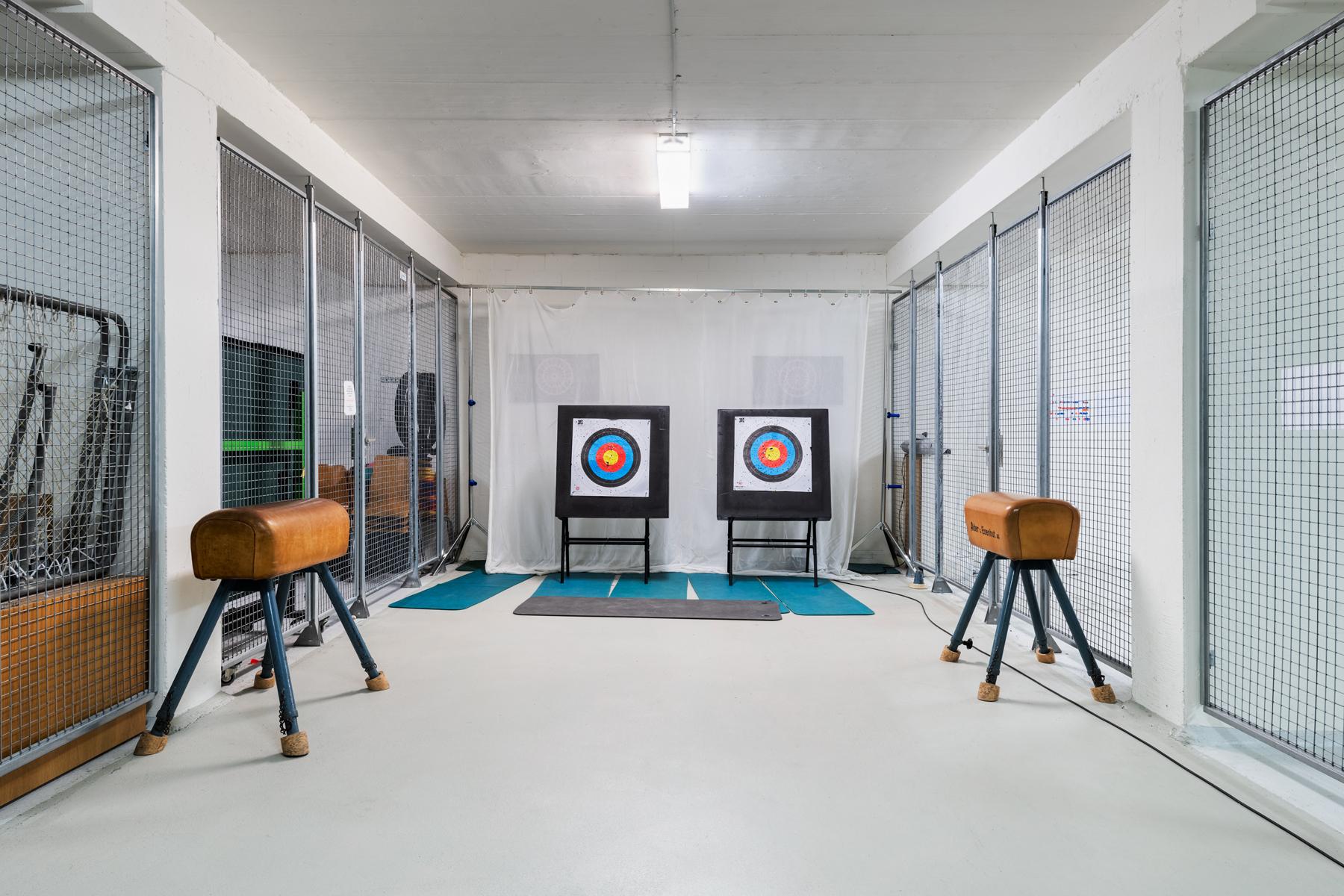 Kellerraum mit verschiedenen Sportutensilien sowie Zielscheiben für das Bogenschiessen.