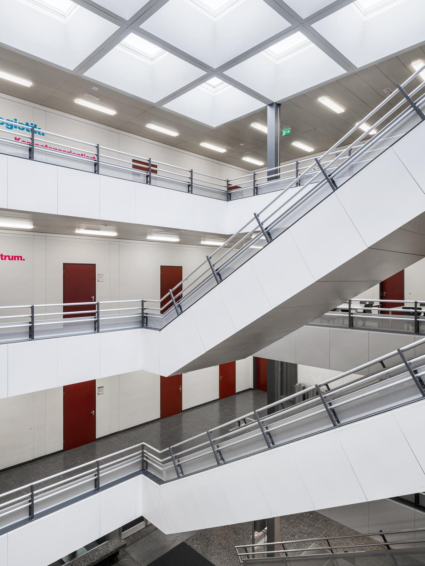 Abbildung der zentralen und hellen Halle über die verschiedenen Etagen mit den dazugehörigen Treppen.