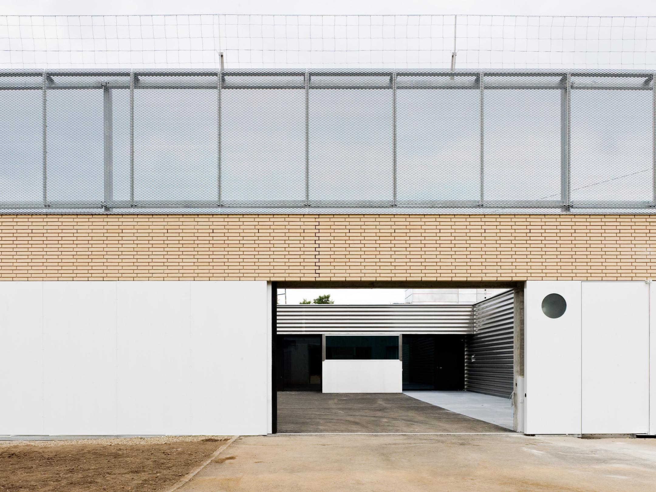 Ansicht an die Fassade von aussen. Ein Tor ist offen, die Wandkrone durch Gitter gesichert.