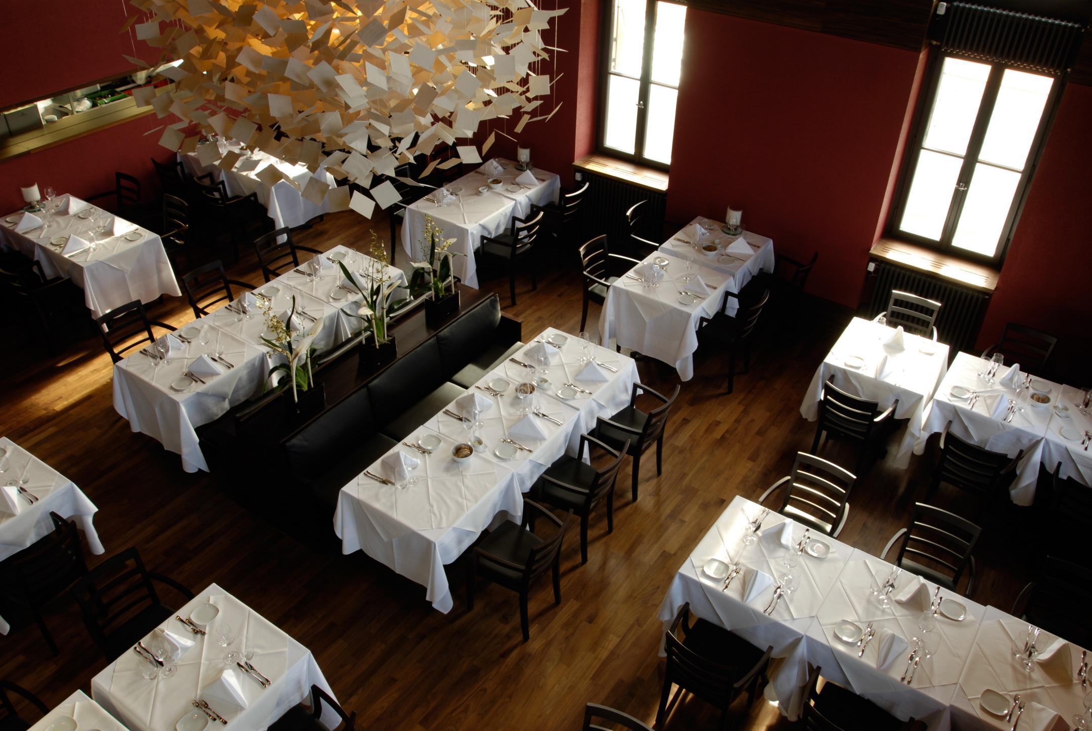 Grosser Saal mit weiss gedeckten Tischen.