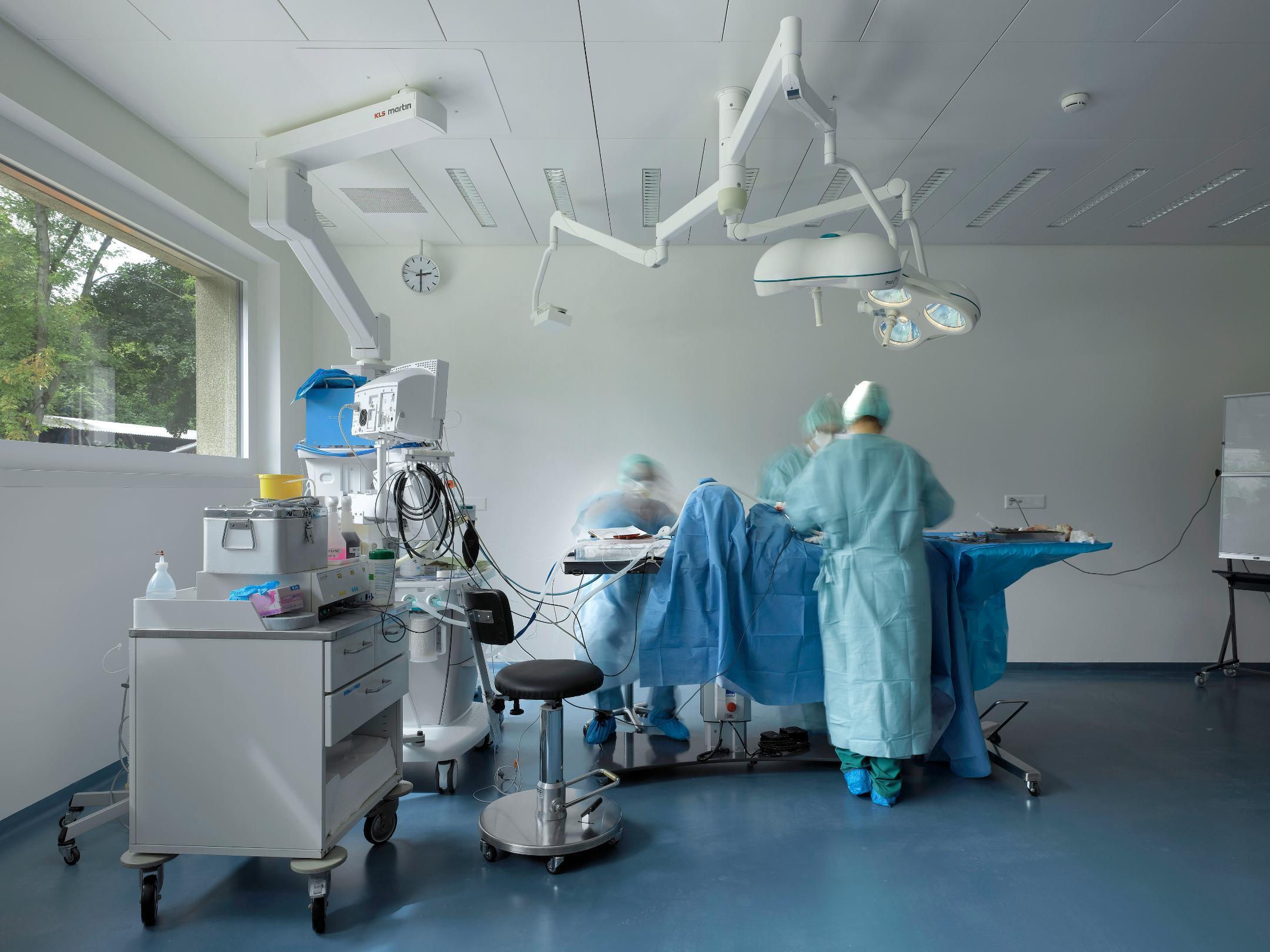 Mehrere Ärzte in OP bei einer gestellten Operation.