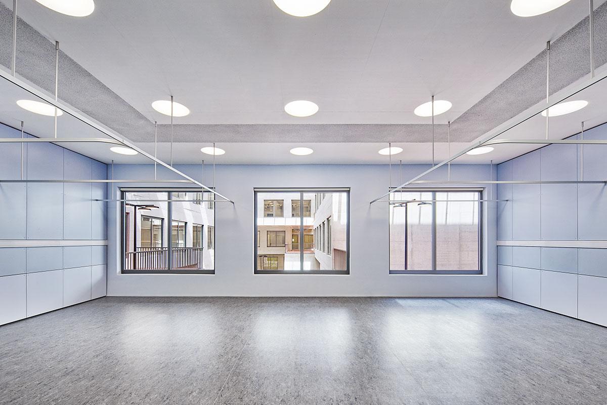 Die Räume um den Innenhof sind hell sowie gut belichtet und verfügen über abwechs-lungsreiche Perspektiven. Die Wände folgen einem auf die Funktionen ausgerichtetem Farbkonzept und sind mit Paneelen aus Leichtbau verkleidet oder gestrichen. In der De-cke sind die Akustikpanelen und Beleuchtung flächenbündig integriert. 