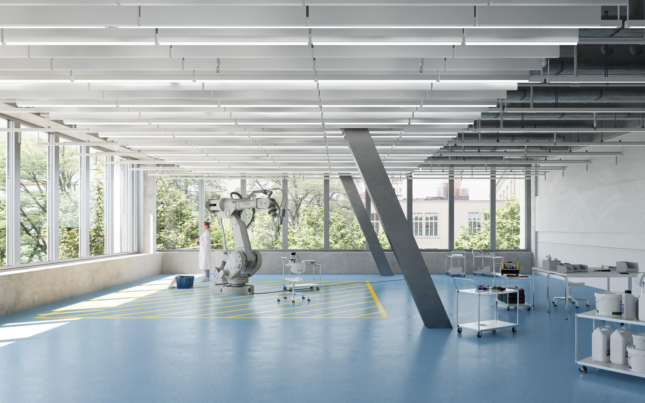 Grosser Raum mit blauem Boden und zwei Stützen im Raum. Spärlich eingerichtet mit Laborgeräten.