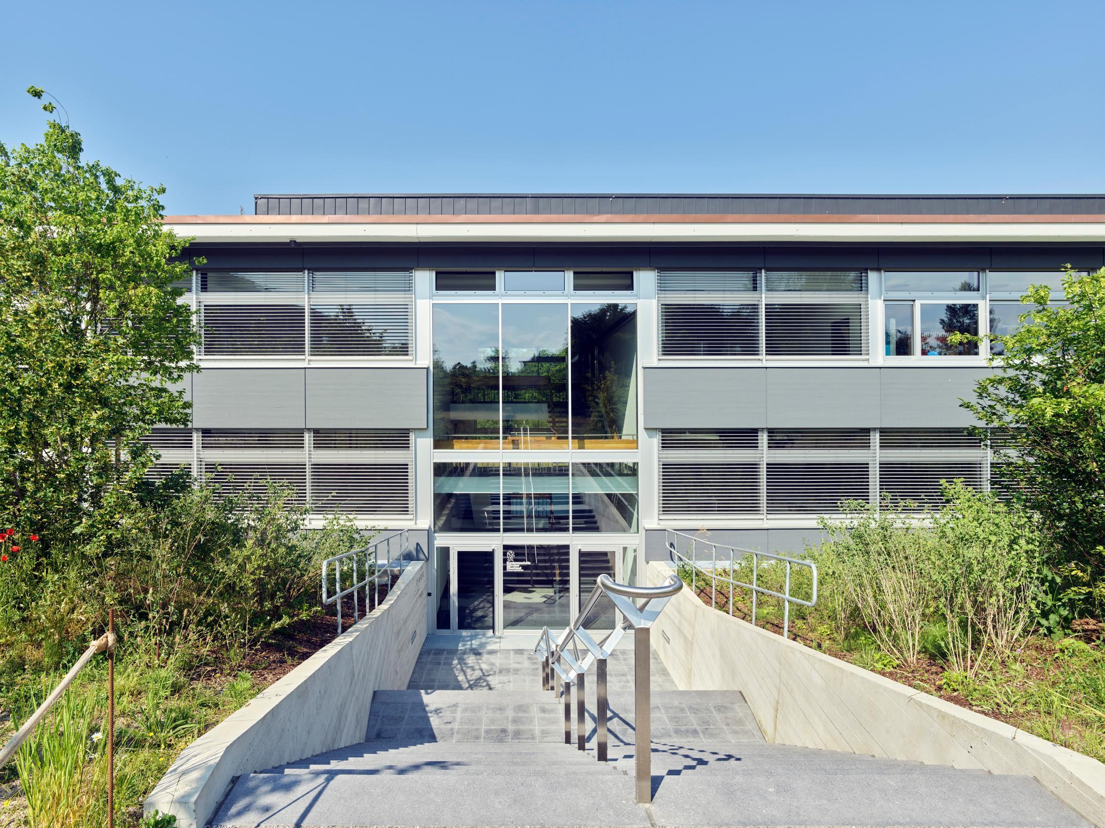 Fotografie der Westfassade, auf welchem der Eingang ersichtlich ist.
