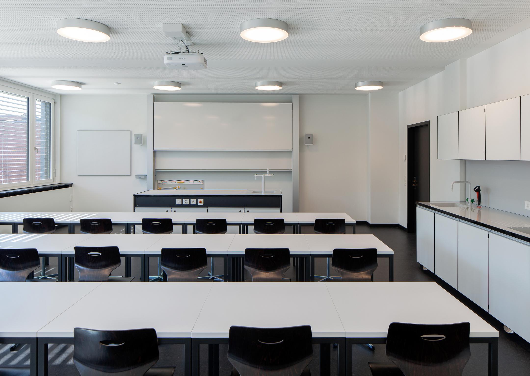 Bestuhltes Klassenzimmer mit White-Board.