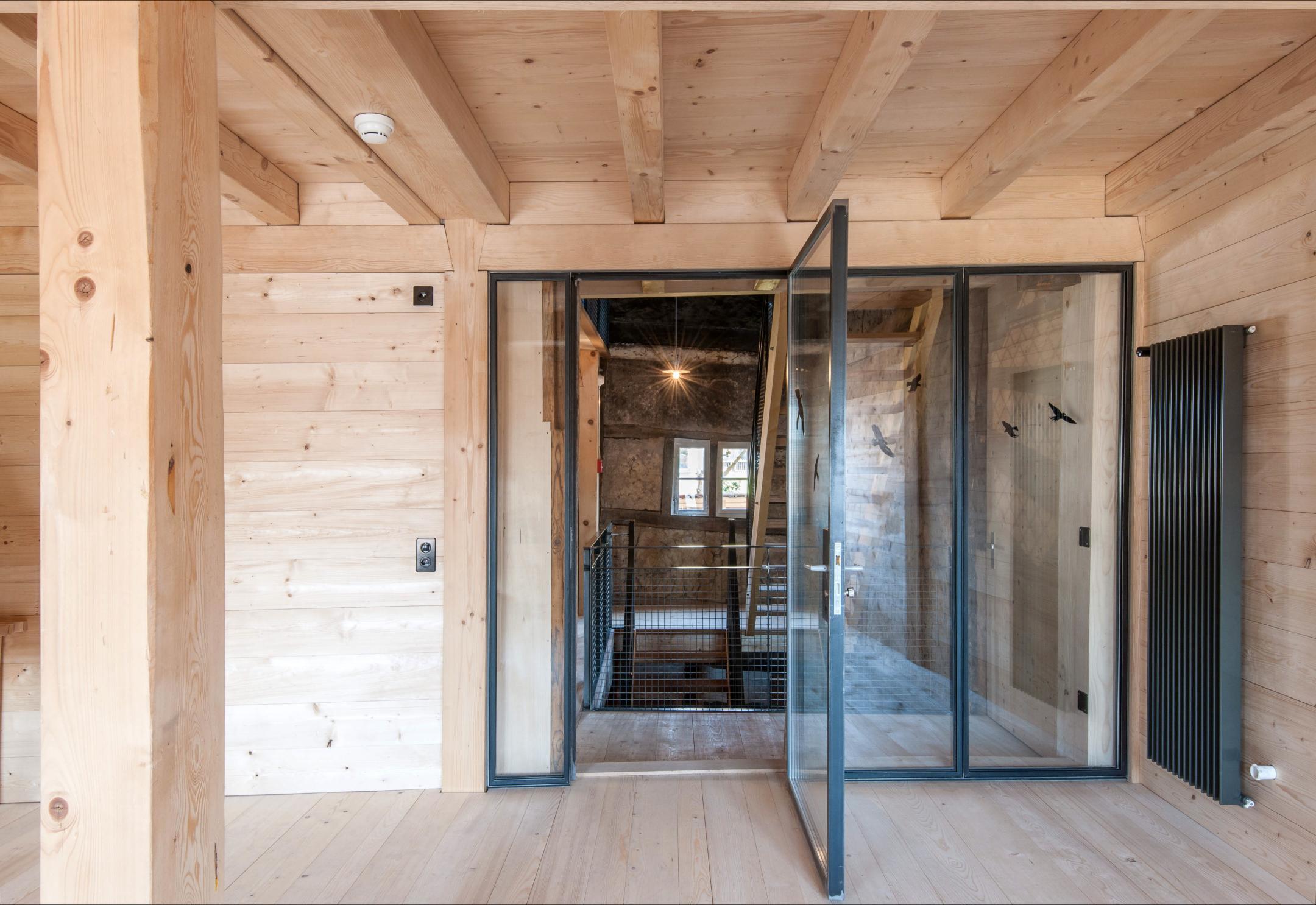 Innenraum in Holz mit alten, restaurierten und neuen Elementen.