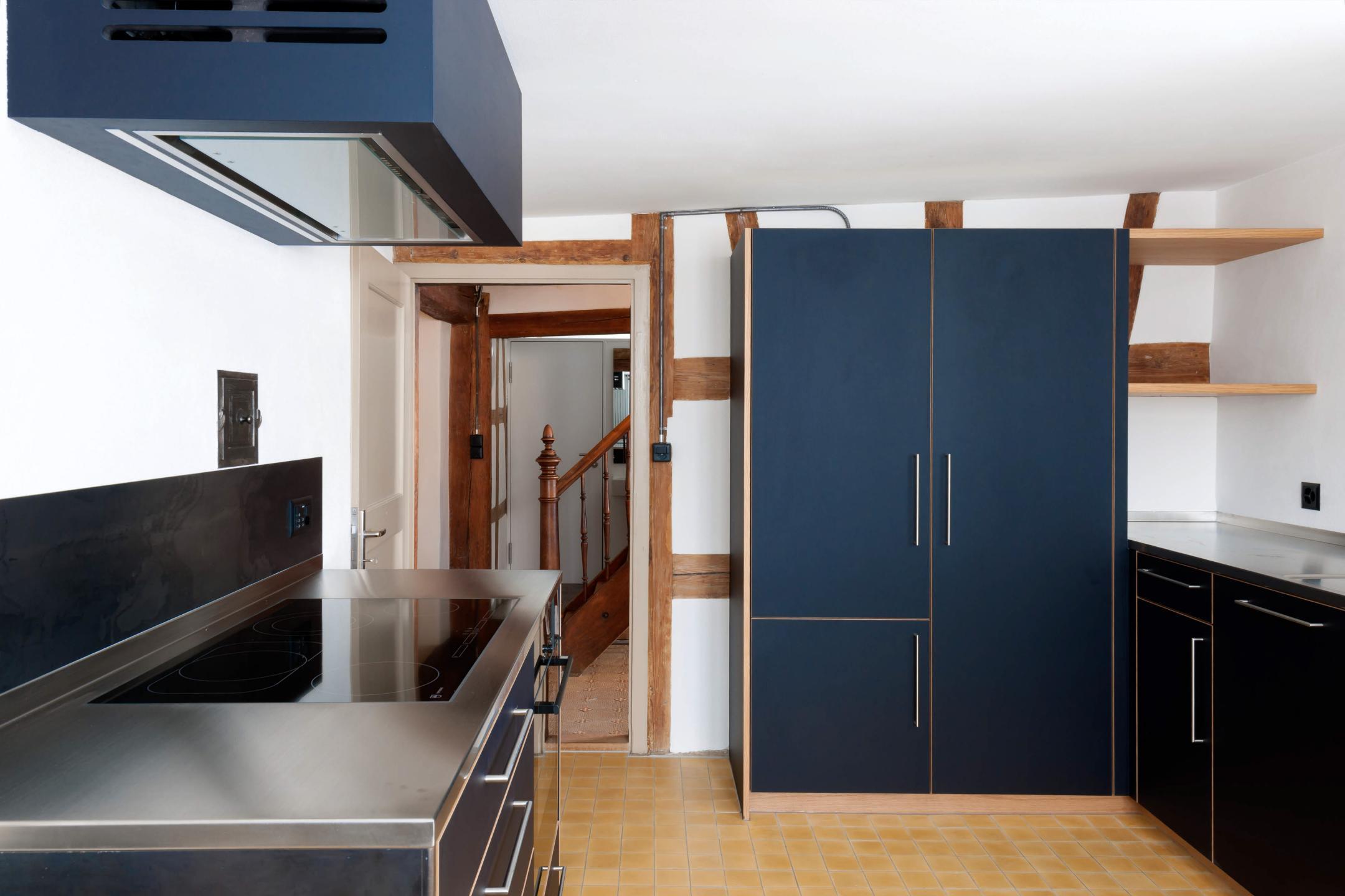 Küche mit modernen Geräten und blauen Schrankfronten.