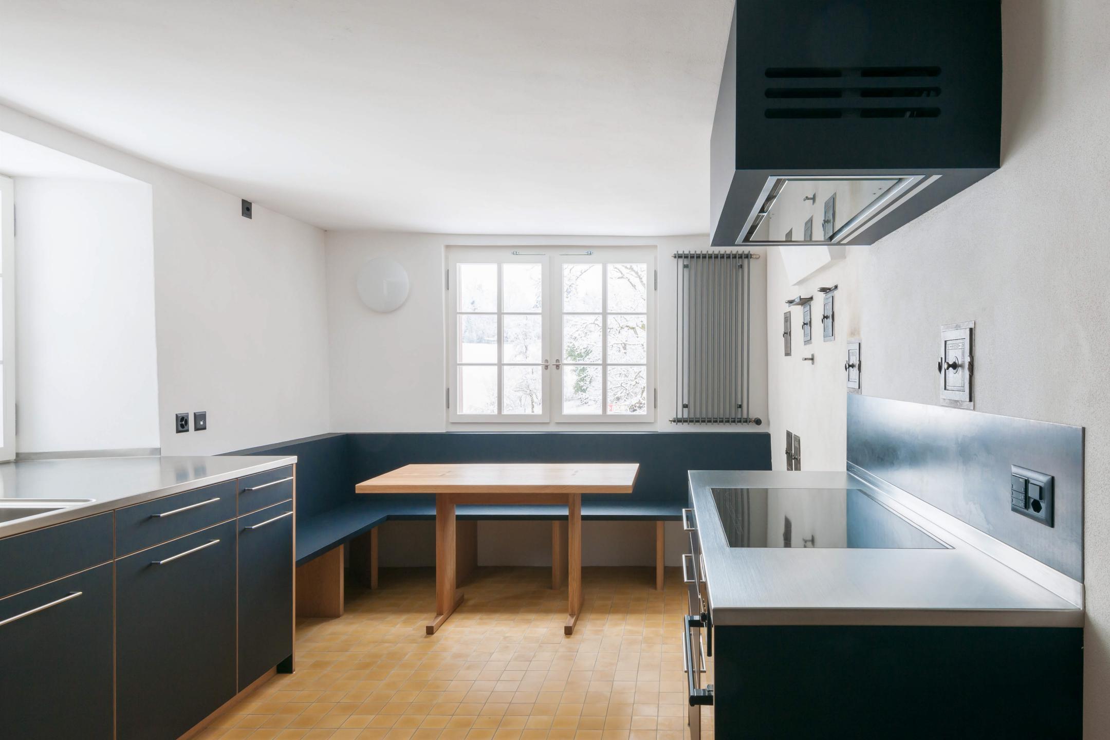 Küche mit modernen Geräten und blauen Schrankfronten.