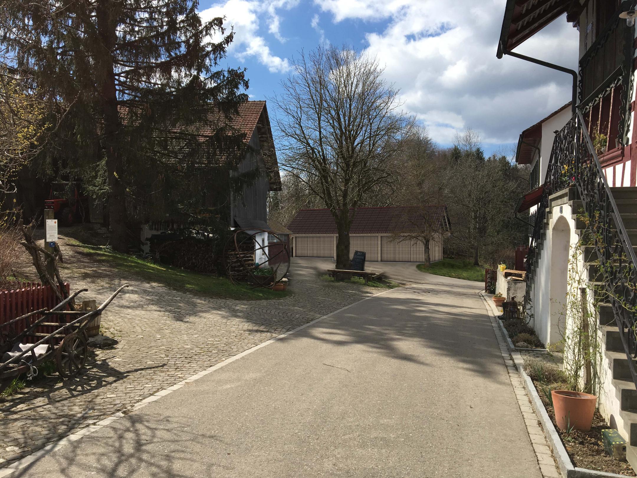 Blick vom Menzihaus auf den Hofplatz mit Stall und einer Visualisierung der neuer Remise.