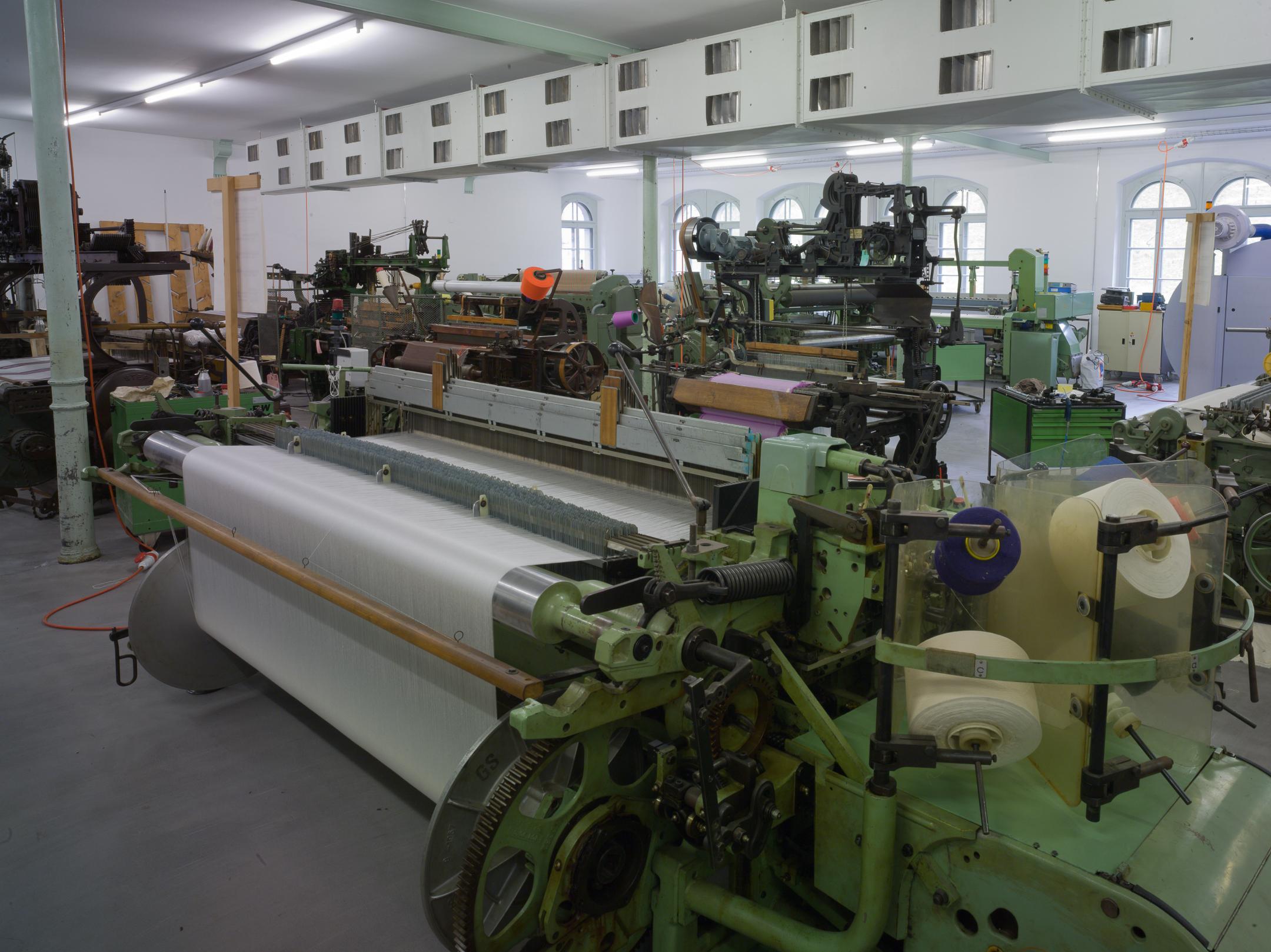 Ausstellungsraum mit mehreren älteren Webmaschinen.