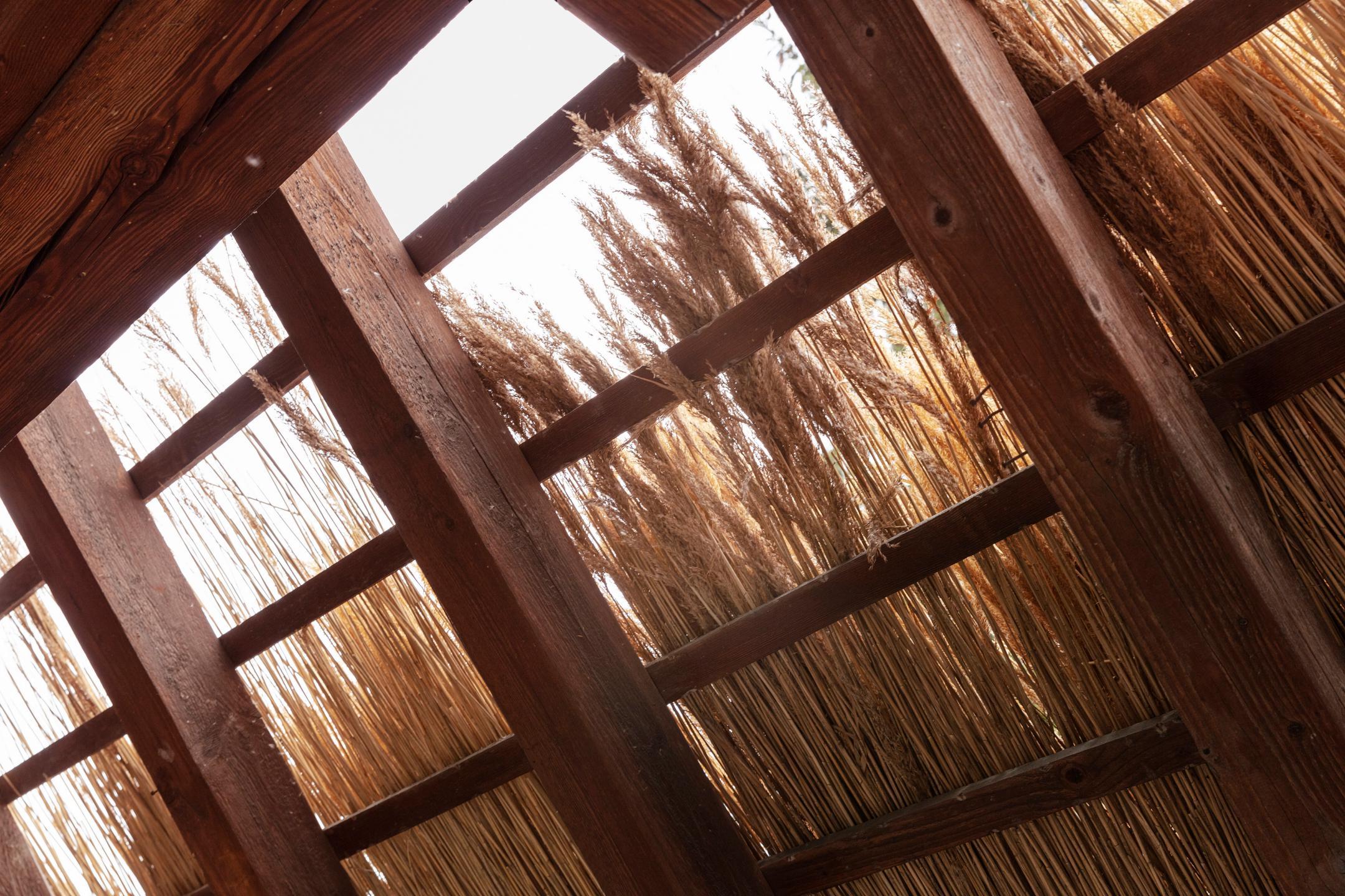 Detailaufnahme des Strohdaches von unten während dem Bauprozess.