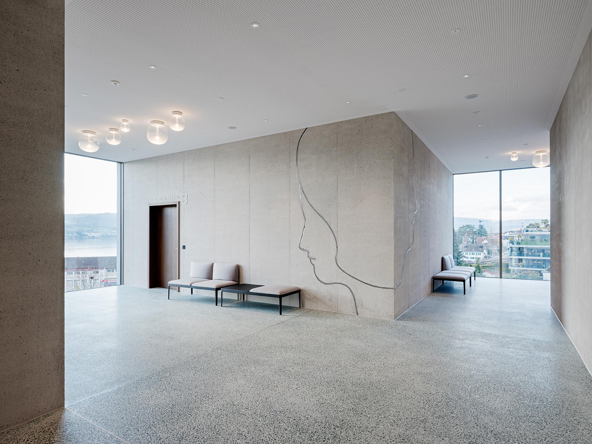 Erschliessungs- und Wartebereich vor den Gerichtssälen mit Wänden aus Beton und Terazzo-Boden.