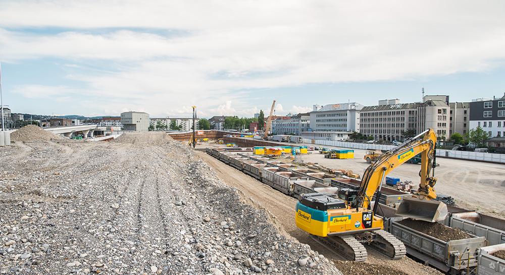Eine Kiesaufschüttung auf der Brache, rechts im Bild ein gelber Bagger: Die PJZ-Baustelle im Juli 2017.