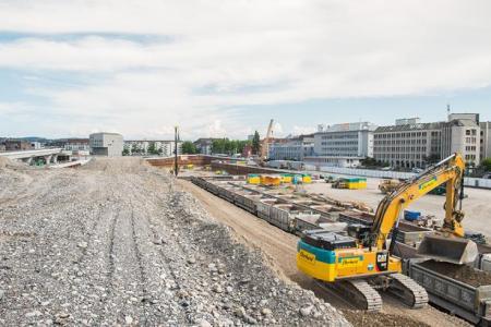 Eine Kiesaufschüttung auf der Brache, rechts im Bild ein gelber Bagger: Die PJZ-Baustelle im Juli 2017.