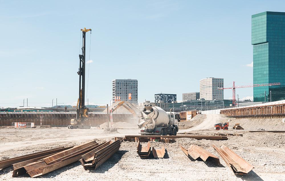 Ein Zementmischer und Metallrinnen auf der Brache, im Hintergrund sind Prime Tower, Toni-Areal und weitere Hochhäuser sichtbar: Die PJZ-Baustelle im Juli 2017.