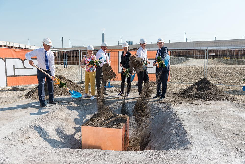 Kantonsvertreter und Bauunternehmer schütten Grundstein zu.