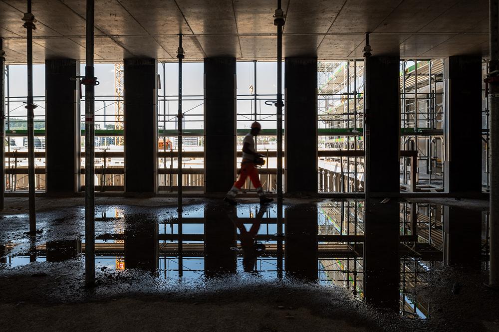 Ein Bauarbeiter im Innern eines Gebäudes auf der PJZ-Baustelle im Juni 2018, im Gegenlicht aufgenommen.