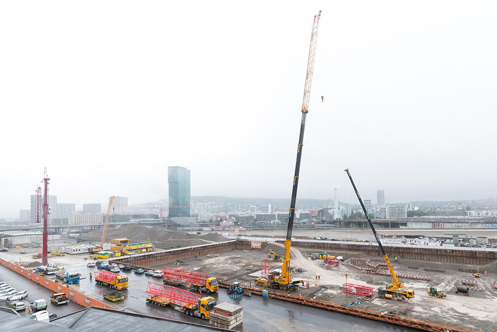 Lastwagen und verschieden grosse Kräne auf der PJZ-Baustelle im September 2017.