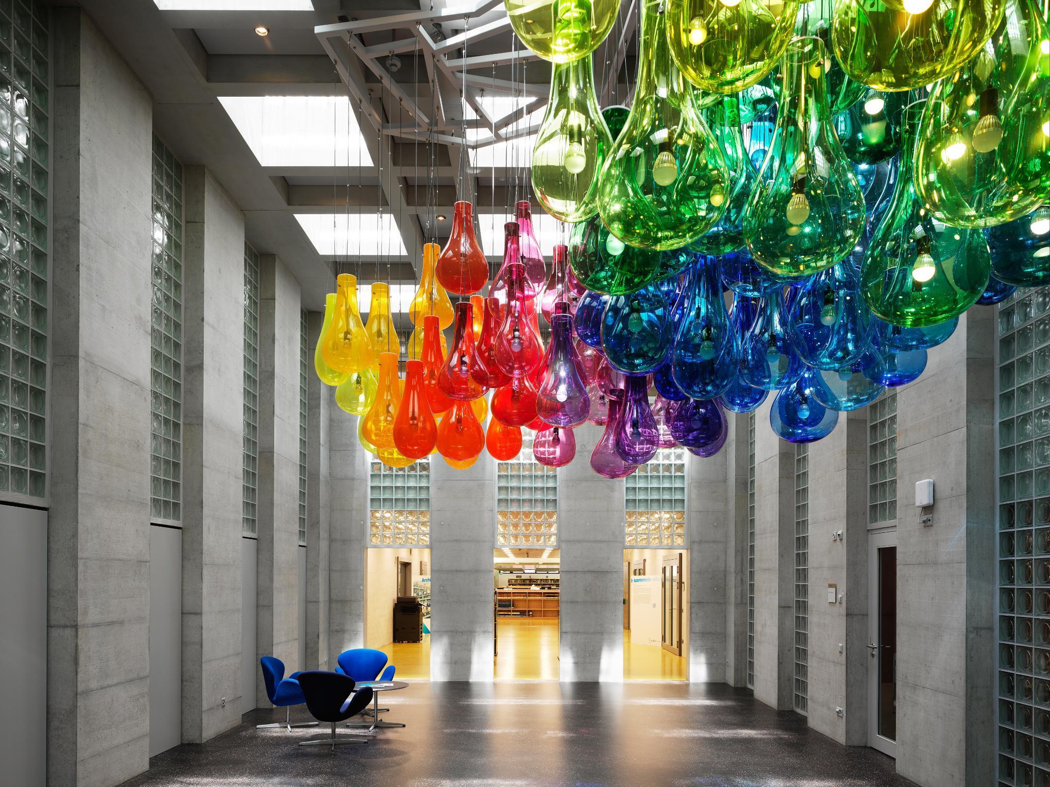 Grosser Überhoher Innenraum mit grossen, etwa ein Meter hohen farbigen Glasgebliden an der Decke.