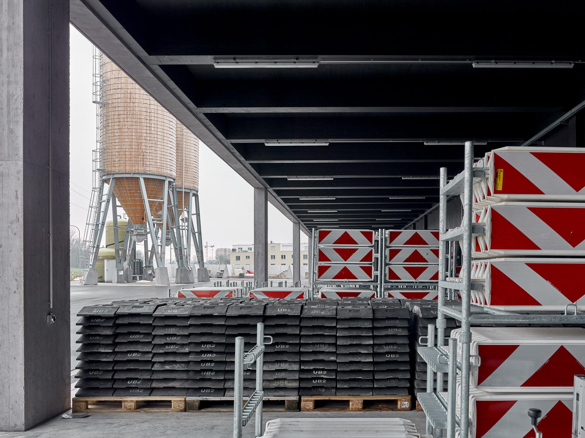Gedecktes Aussenlager der Einstellhalle mit Silos im Hintergrund.
