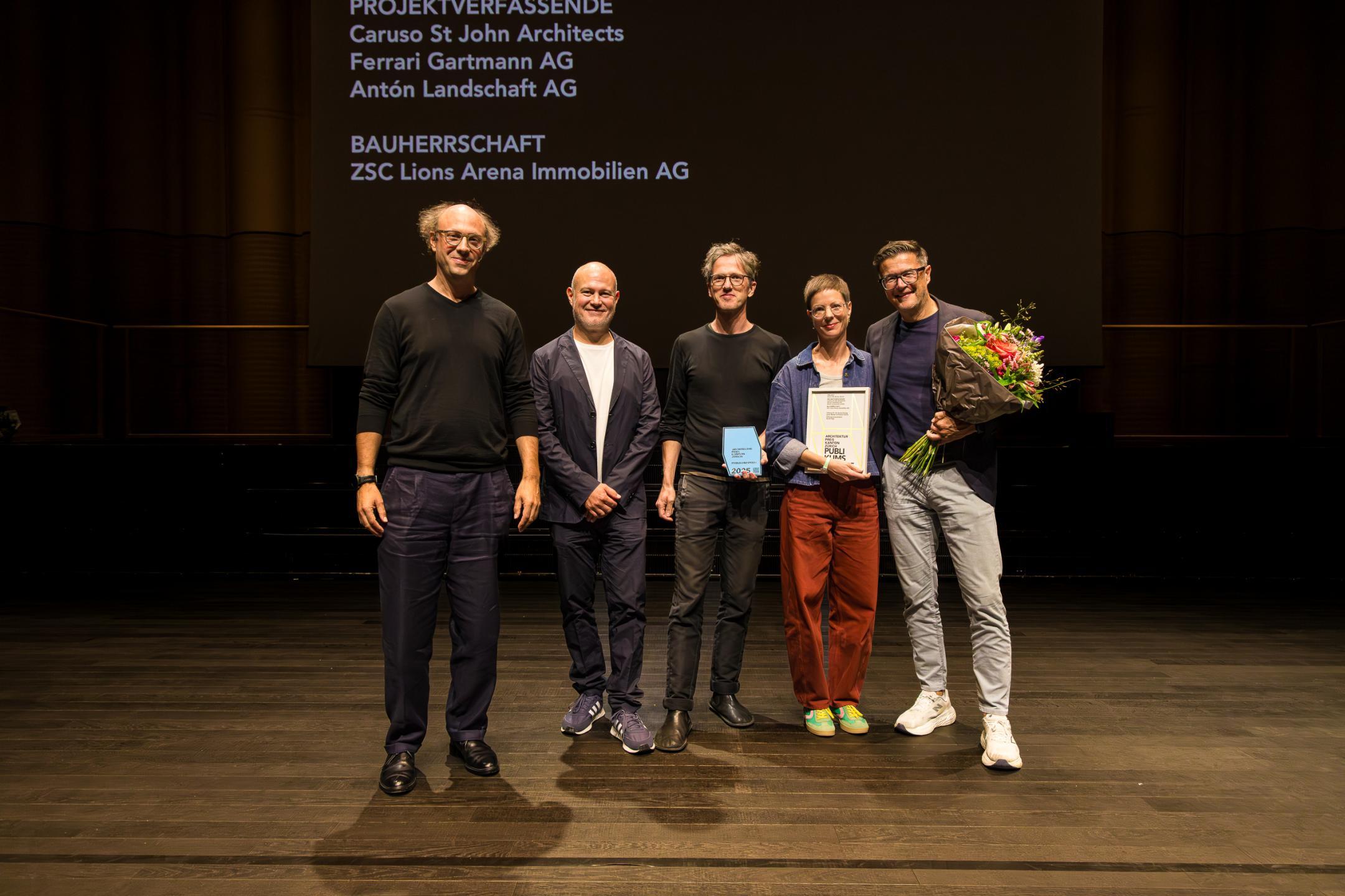 Die Preisträger posieren mit Blumenstrauss für das Foto.