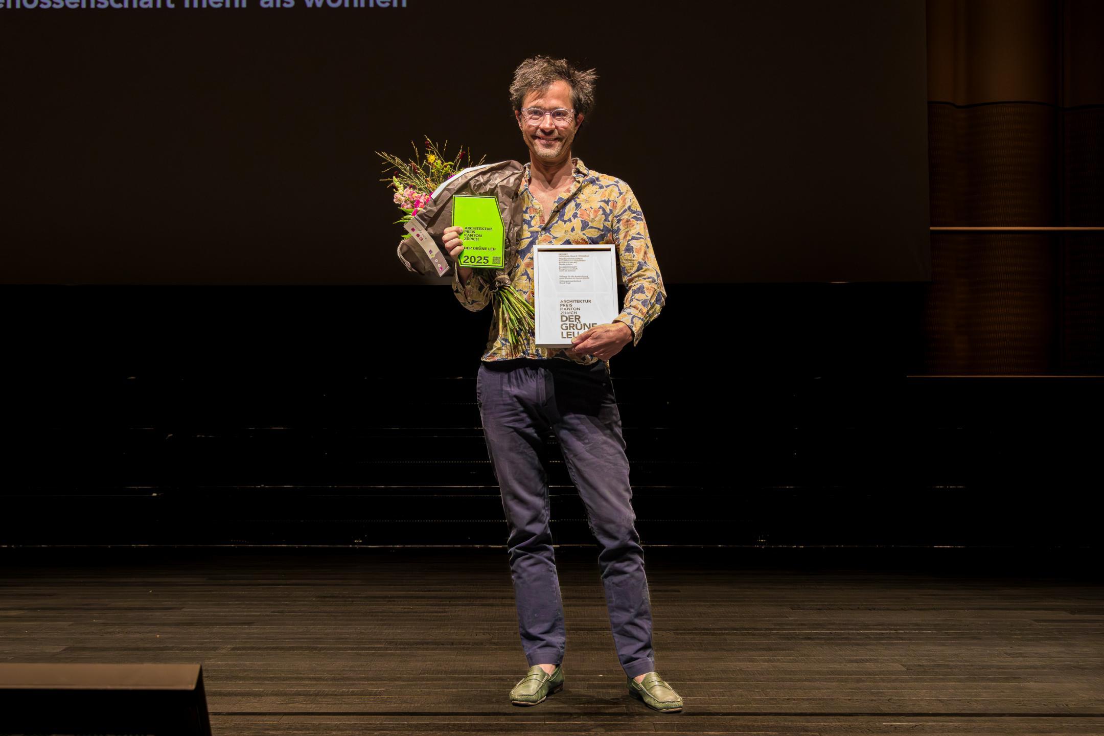 Die Preisträger posieren mit Blumenstrauss für das Foto.