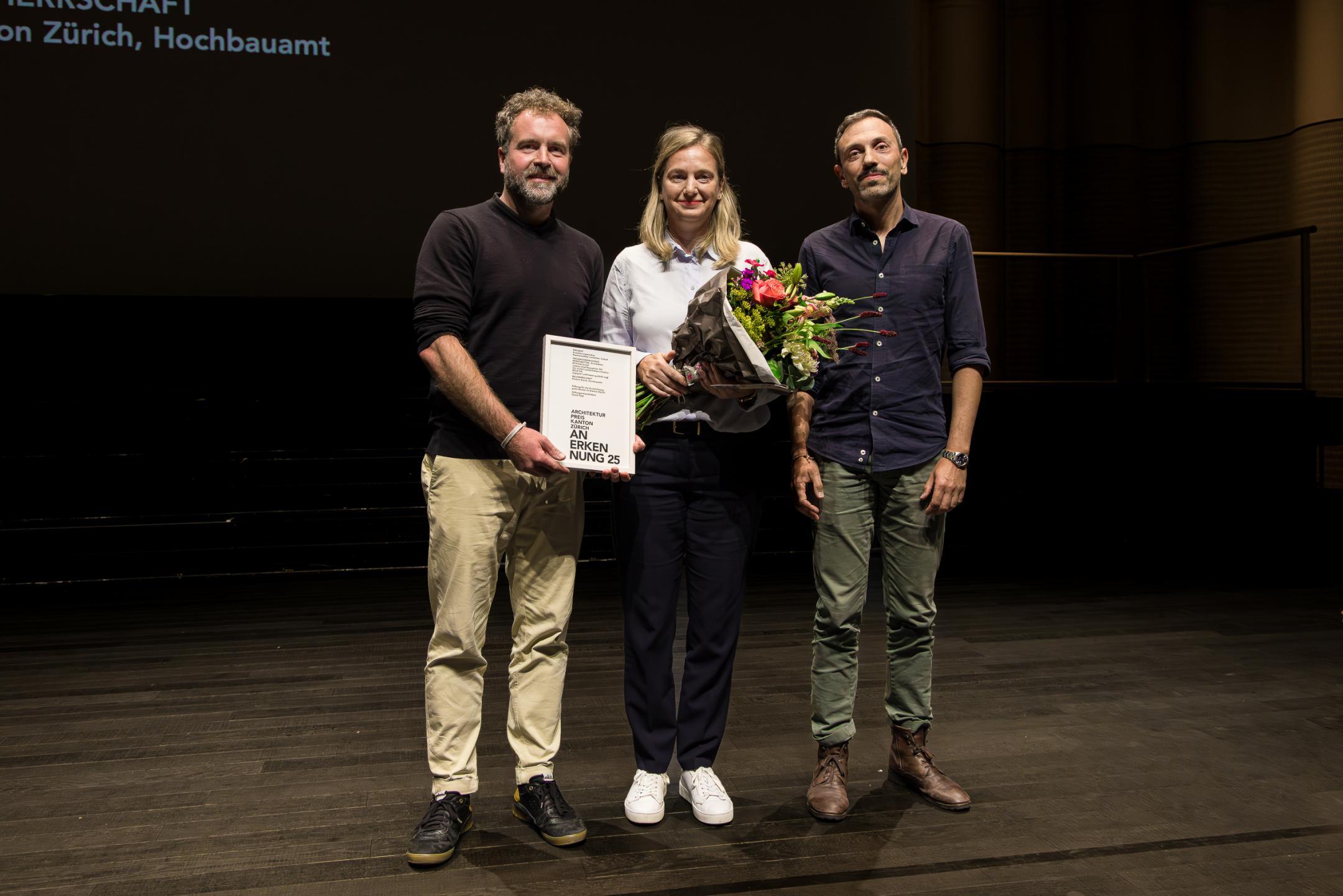 Die Preisträger posieren mit Blumenstrauss für das Foto.