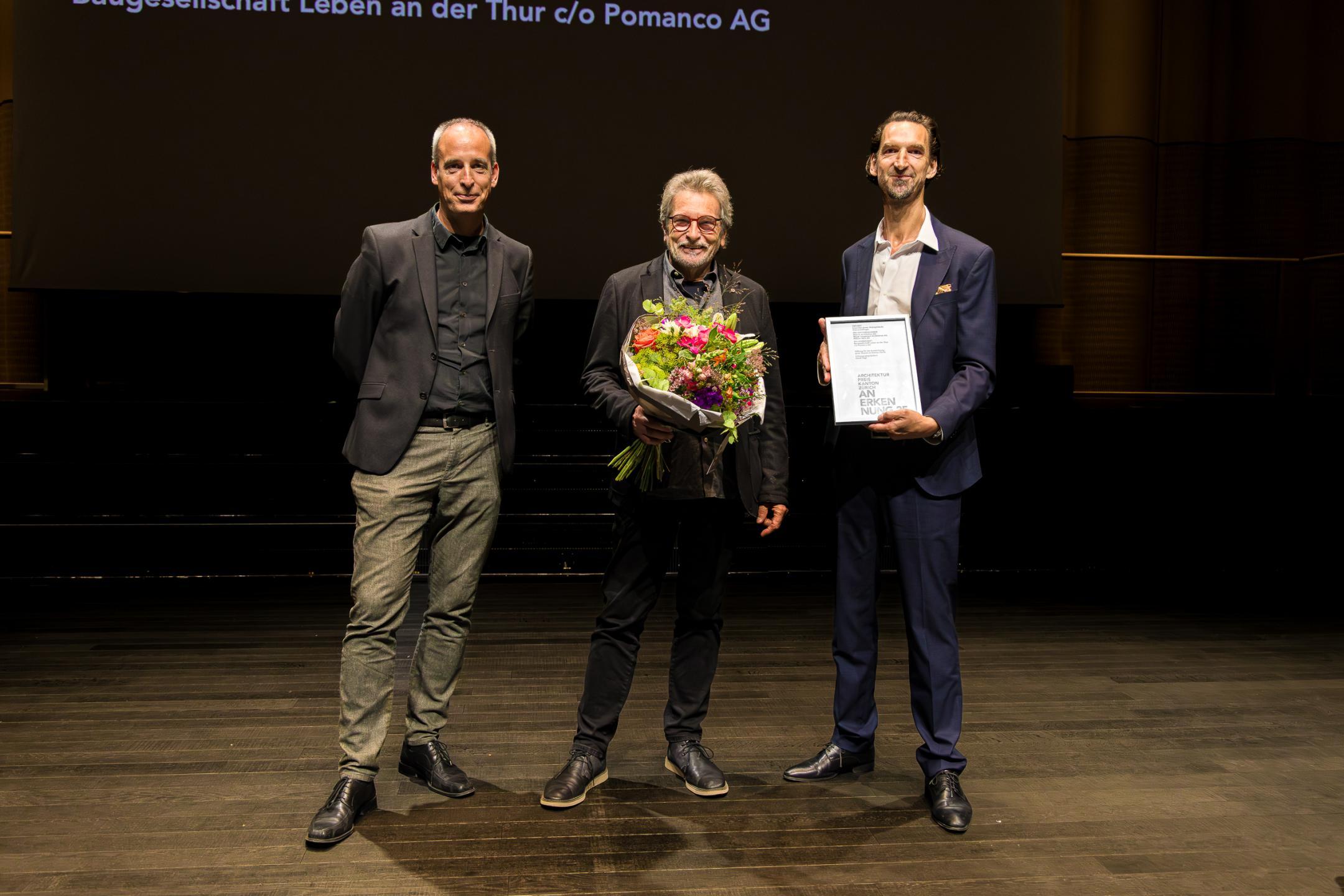 Die Preisträger posieren mit Blumenstrauss für das Foto.