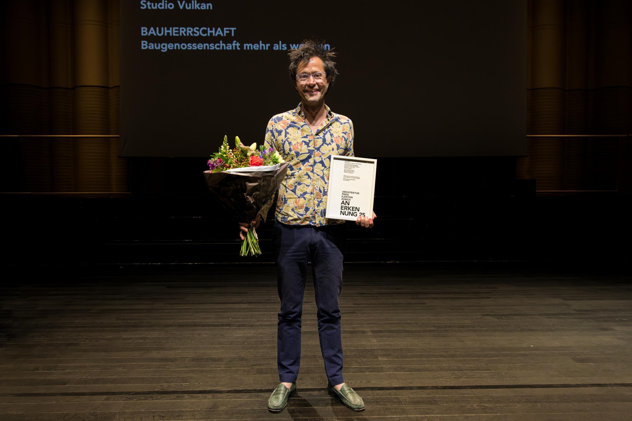 Die Preisträger posieren mit Blumenstrauss für das Foto.