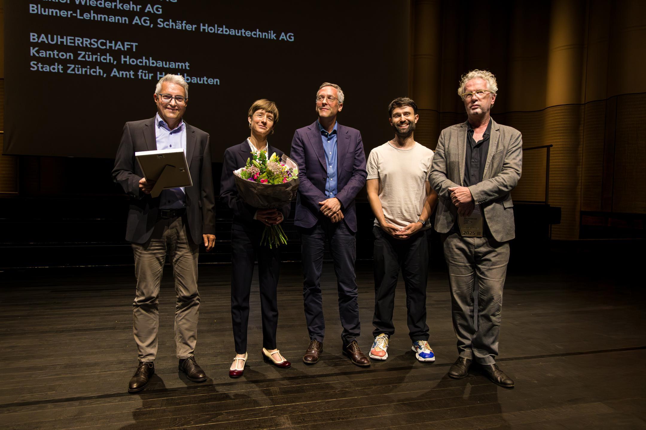 Die Preisträger posieren mit Blumenstrauss für das Foto.