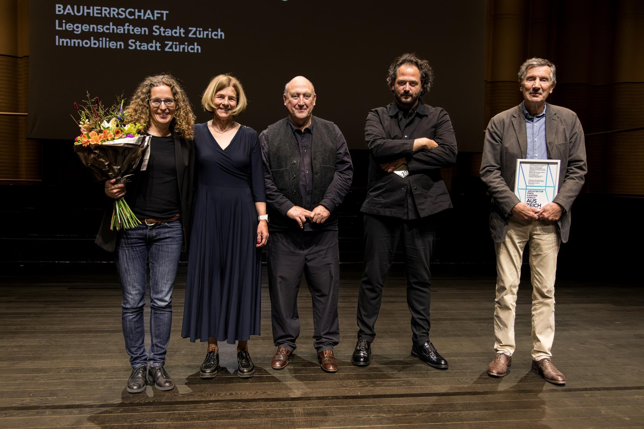 Die Preisträger posieren mit Blumenstrauss für das Foto.