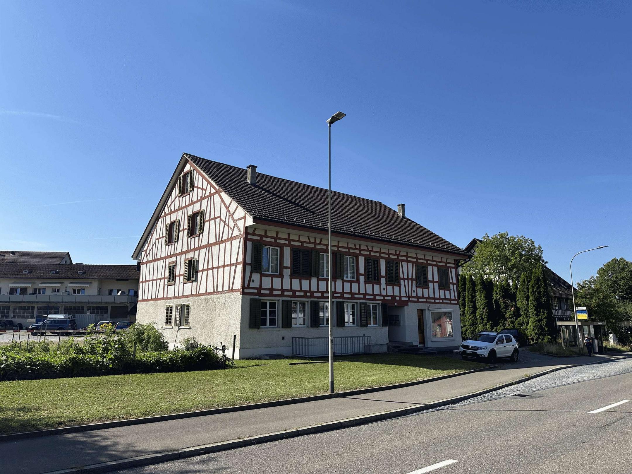 Wehntalerstrasse, Trottoir und Rasenplätzchen vor Mehrfamilienhaus in Höri.